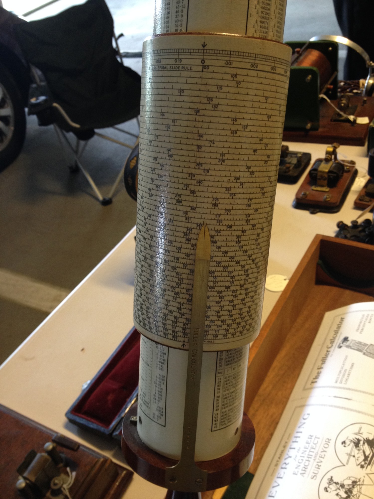 Figure 3 — Close view of a Fuller's scale cylinder: dozens of fine helical turns closely printed with graduations and small numerals, the brass index bar running down the front.