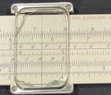 Figure 2 — A close view of my 4071-3's cursor over the front face: the glass window is cracked across the top left corner and along the bottom edge, with greenish fracture edges, while the hairline is intact …