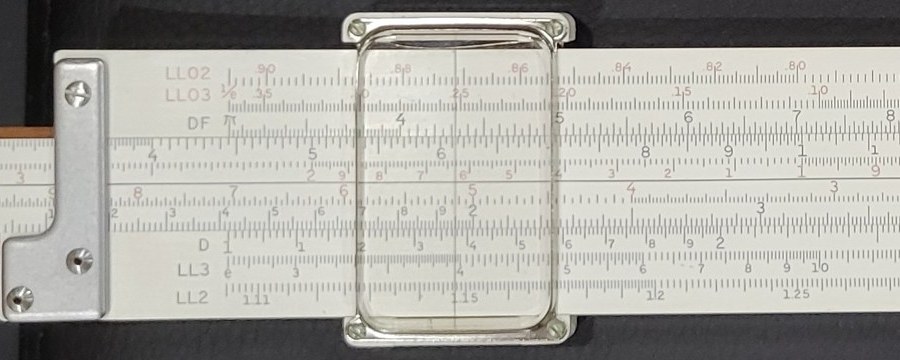 Figure 2 — A close view of my 4081-3's cursor over the left half of the log-log face, showing the metal top and bottom bars, the four corner screws, the clear window with rounded corners and the single hairli…