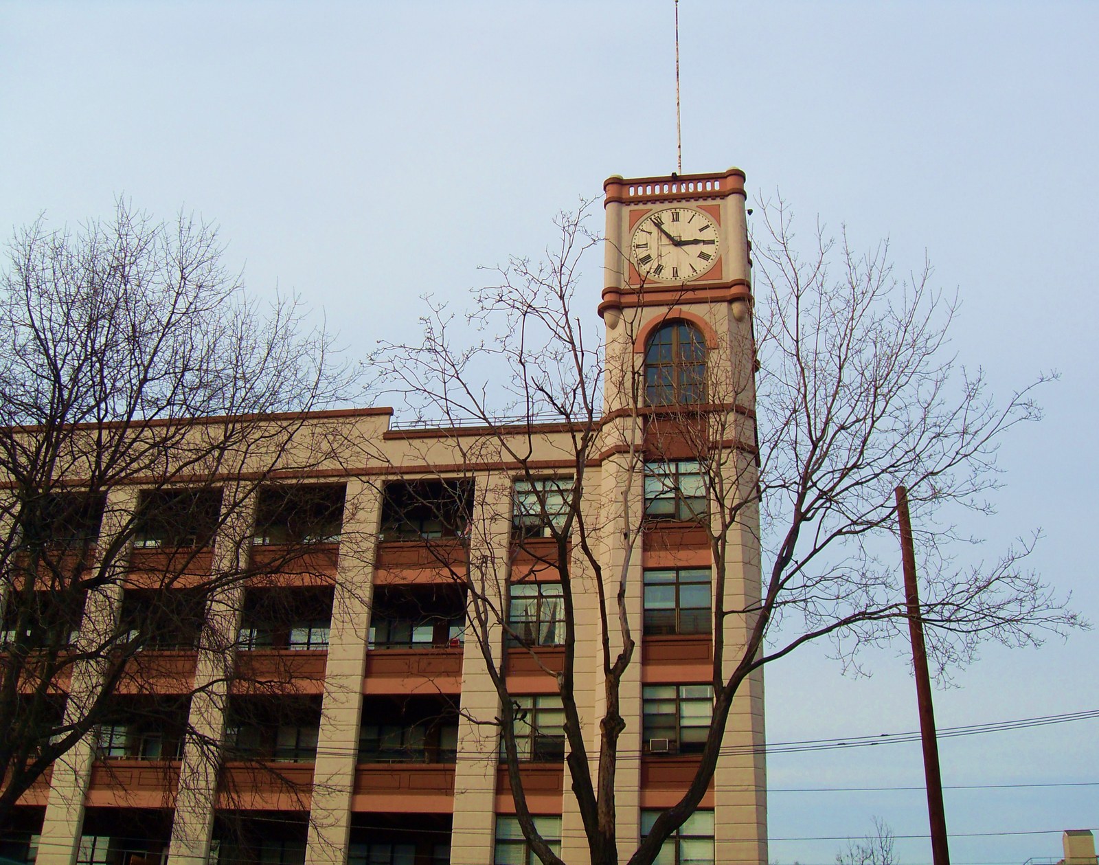Figure 2 — The Keuffel and Esser Manufacturing Complex in Hoboken, New Jersey: a red-brick factory with a white clock tower, seen through bare winter trees.