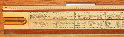 Figure 2 — The back of a Nestler 23 R: a printed table of constants on celluloid over the mahogany stock, with the semicircular cut-out at the left exposing the slide.