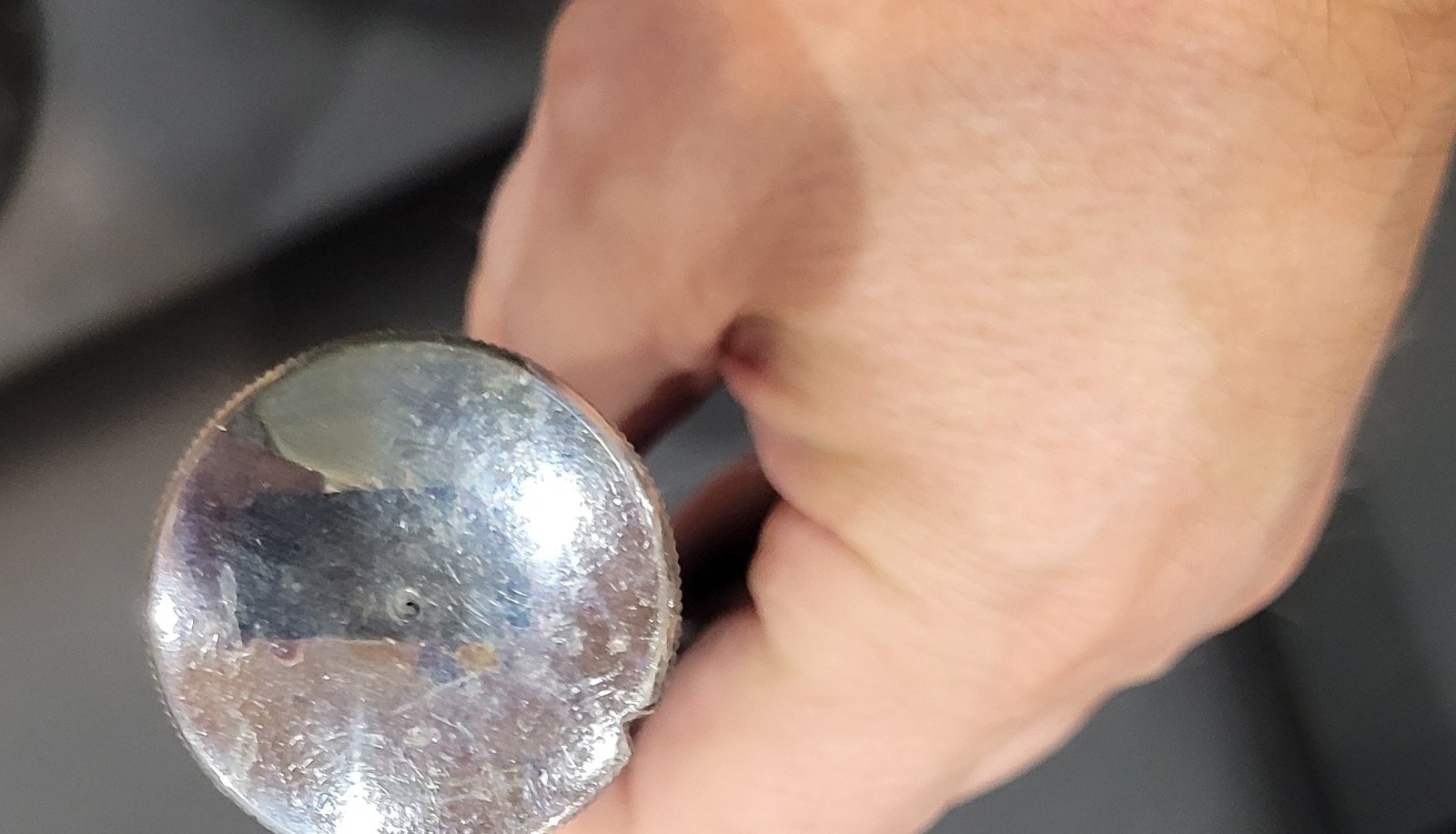 Figure 4 — The knurled end knob of my Otis King, plated, with scratches and a small notch cut in its rim.