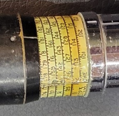 Figure 3 — Close view of the short exposed run of holder scale on my Otis King, between the black cursor tube and the chrome handle, with turns numbered 101, 113, 126, 141, 159, 178 and the word ONE at the ha…