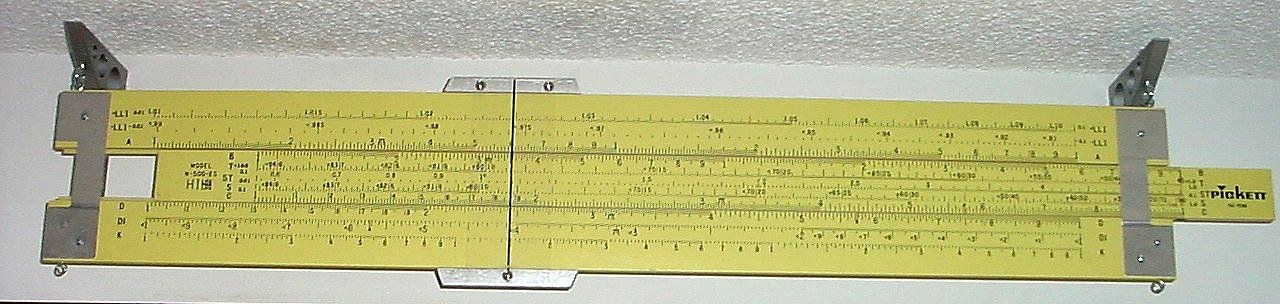 Figure 4 — A four-foot yellow Pickett 500-ES demonstration rule hung on a wall, its scales running the full length between aluminium end plates.